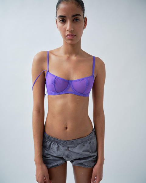 Front of woman wearing purple bra and grey check shorts