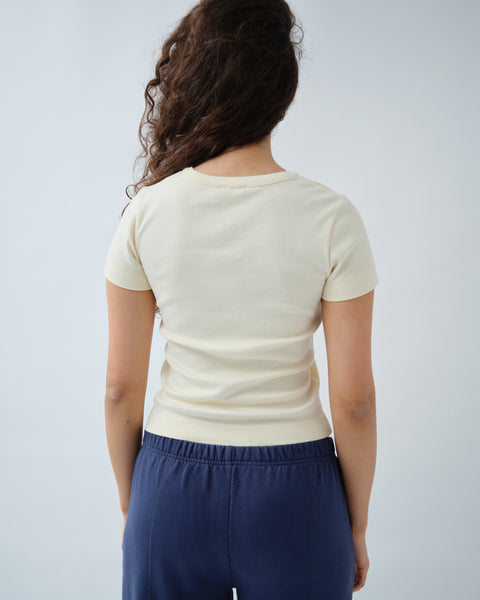 Back of woman wearing yellow v-neck tshirt with navy trousers