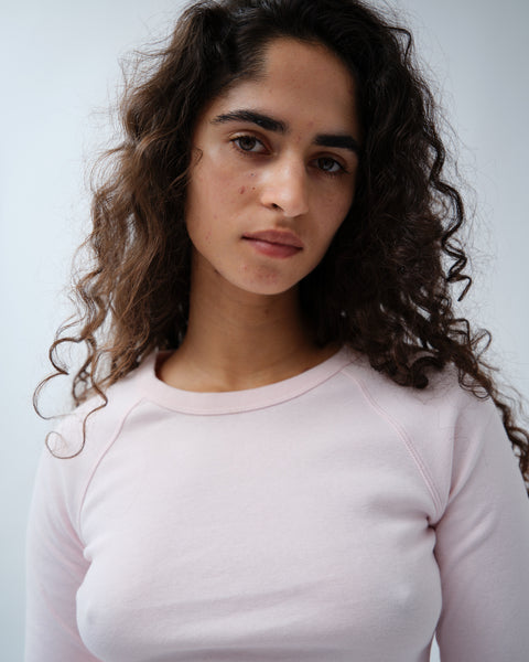 Close up of woman wearing light pink long sleeve tshirt